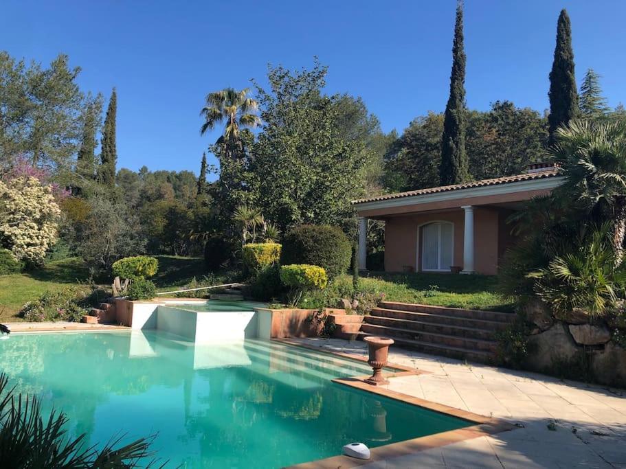 a swimming pool in front of a house at Luxueux Cocon avec parc paysagé avec piscine XXL à débordement, mer et plages 15 minutes in Pierrefeu-du-Var