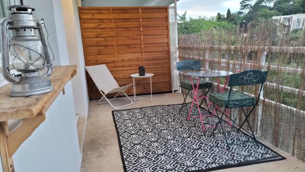 un patio avec une table et des chaises sur un balcon dans l'établissement Joli T2 à Montpellier, à Montpellier
