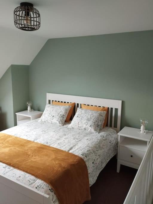 une chambre avec un grand lit avec deux tables de nuit dans l'établissement Le Pré Ducrot, à Saint-Michel