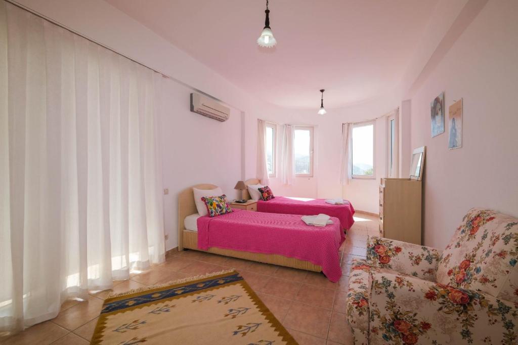 a bedroom with two beds and a couch at Villa Manolya in Kalkan