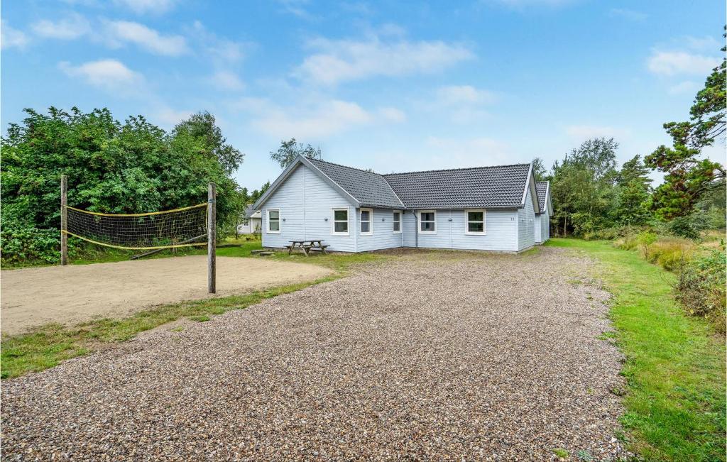 una casa bianca con una rete da pallavolo davanti di Pet Friendly Home In Rømø With Kitchen a Rømø Kirkeby