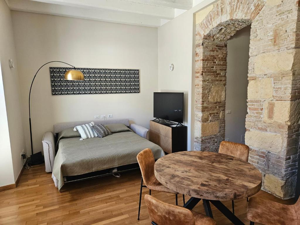 een slaapkamer met een bed, een tafel en een tv bij Appartamento Adiosa in Cagliari