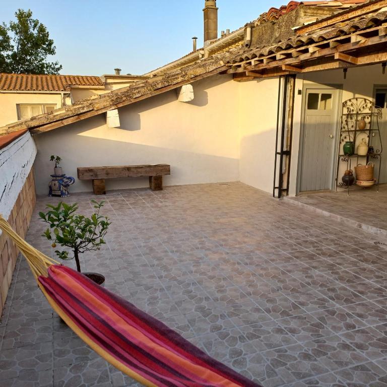a hammock in the courtyard of a house at Maison avec superbe terrasse tropézienne in Adissan