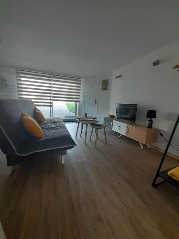 una sala de estar con un sofá y una mesa en Chez Nous, en Tillé