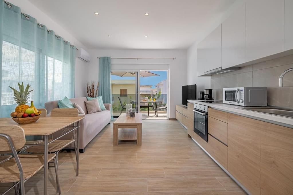 een keuken en woonkamer met een bank en een tafel bij Andreas Rodos Apartment in Rhodos-stad