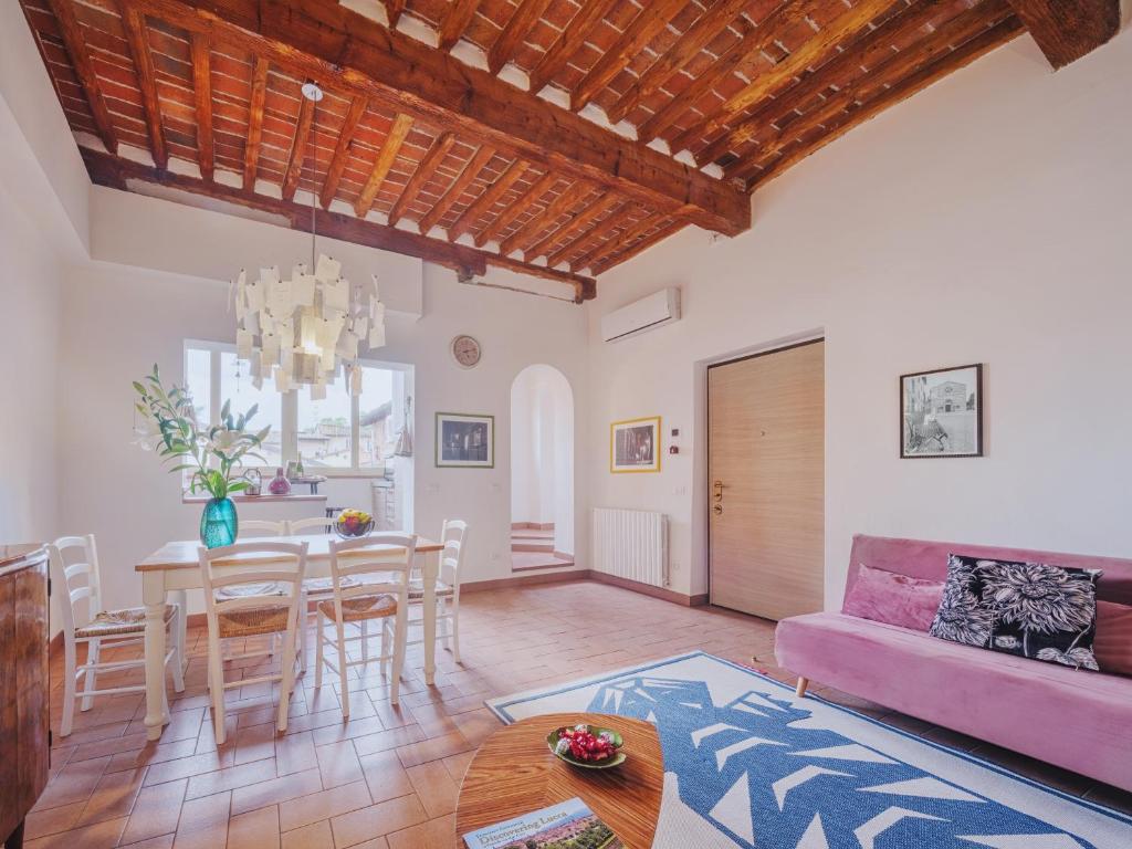 a living room with a table and a pink couch at Casa Aida Luxury Apartment in the Heart of Lucca in Lucca