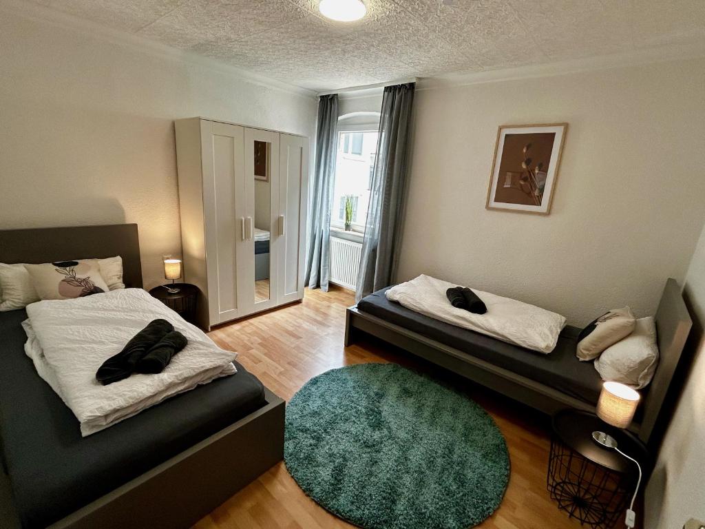 a small room with two beds and a green rug at OhPardon! GAILDORF - Monteurwohnung im 1 OG, Einzelbetten, Garten in Gaildorf