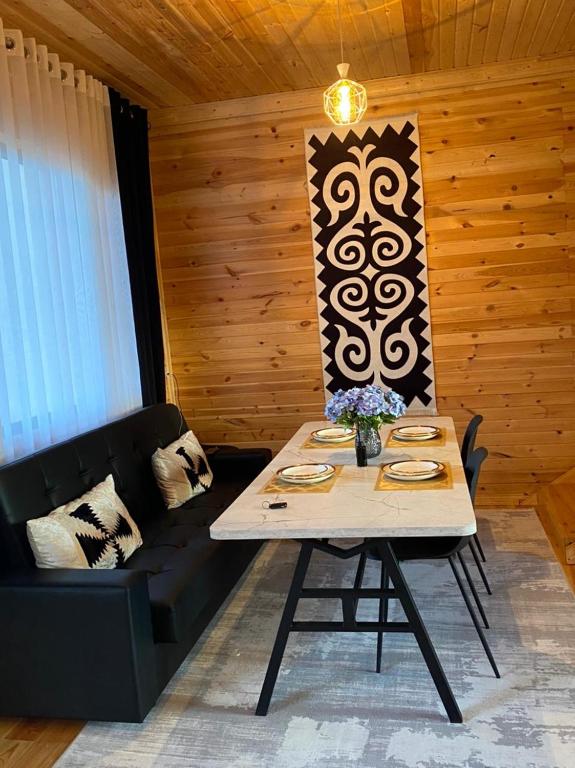 a dining room with a table and a couch at Beach HOUSE in Cholpon-Ata