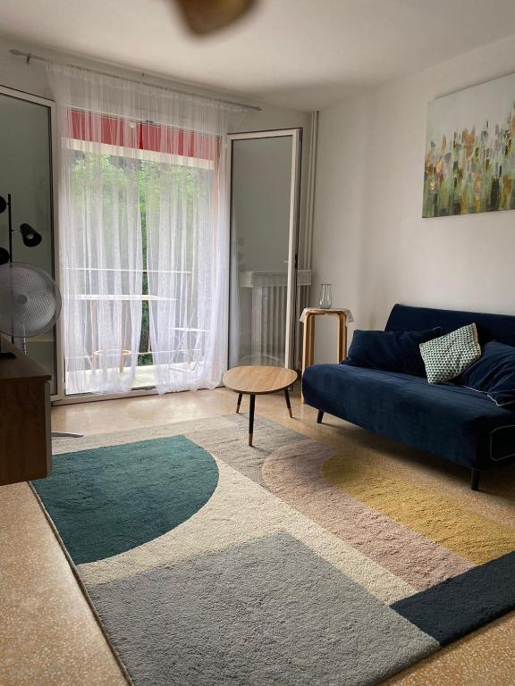 un salon avec un canapé bleu et une table dans l'établissement Grand Appartments Sappia, à Nice