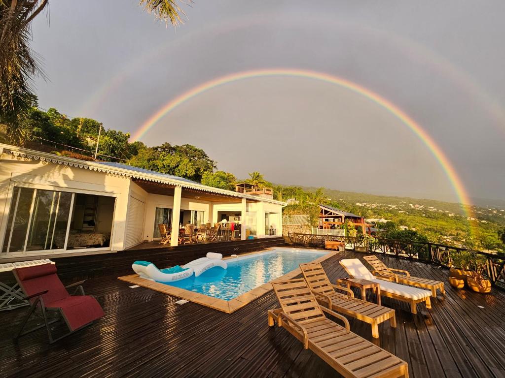 Un arcoíris sobre una casa con piscina y un tobogán. en Home Ocean 360°, en Saint-Leu