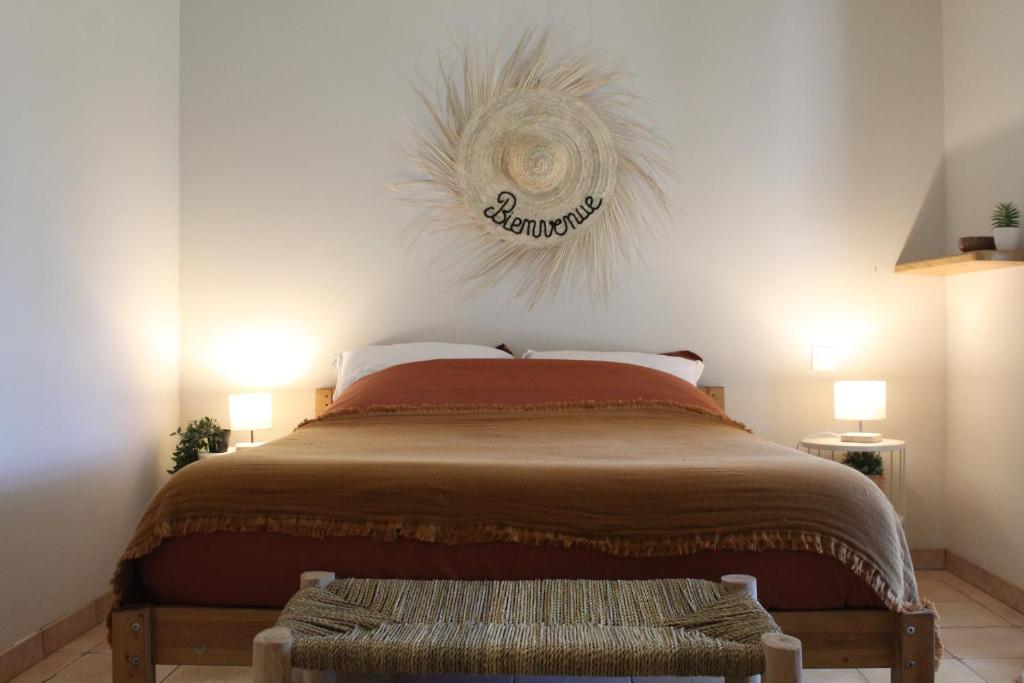 une chambre avec un lit avec un panneau sur le mur dans l'établissement Mas Eva, à Mouriès