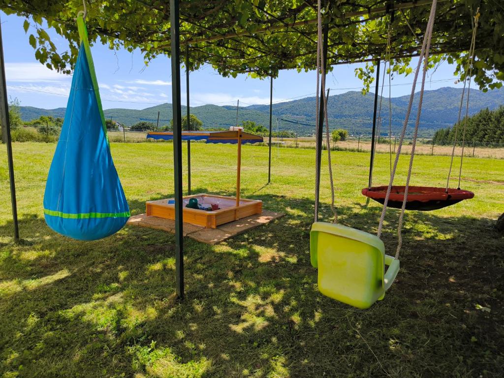 un'altalena con un ombrellone blu e una panchina di Holiday Home Sinac 2 a Otočac