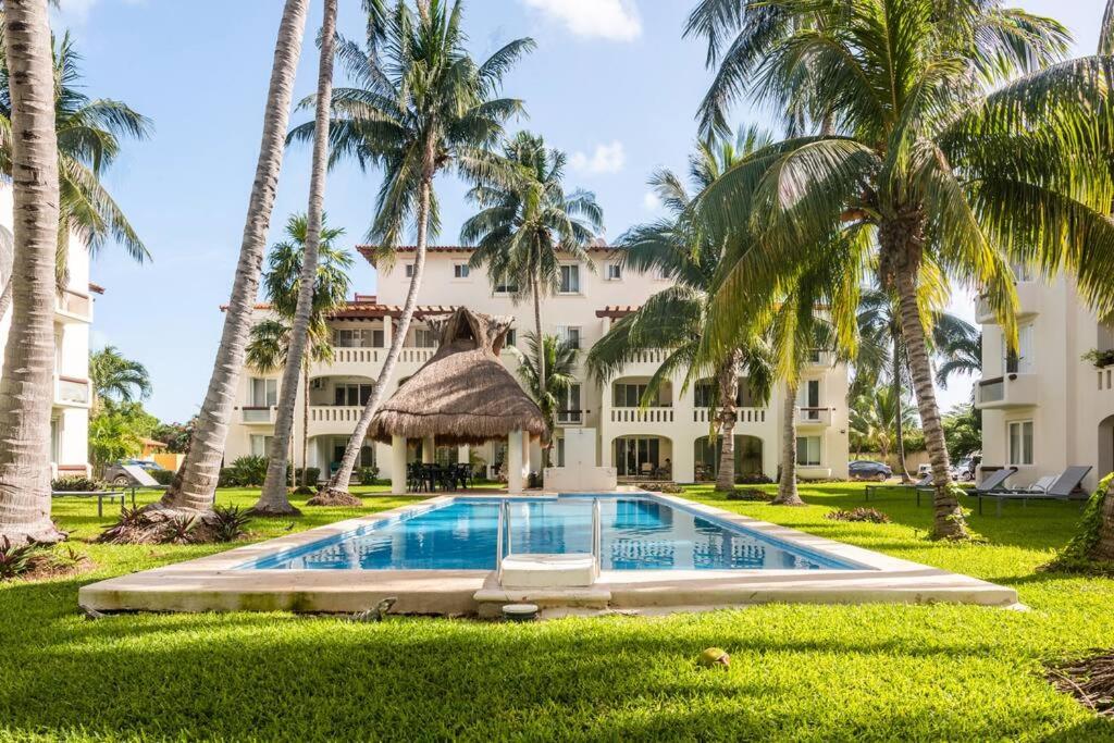a resort with a swimming pool and palm trees at Stunning condo in excellent location in Cancún