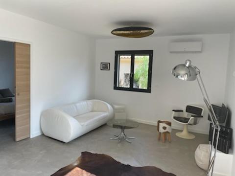 - un salon avec un canapé blanc et une lampe dans l'établissement un petit coin de paradis entre mer et terre, à La Cadière-dʼAzur
