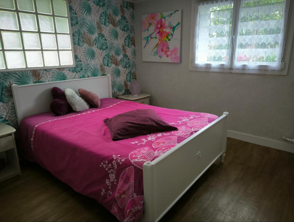 - une chambre avec un lit rose et des oreillers dans l'établissement Chez nous chez vous, à Vaires-sur-Marne