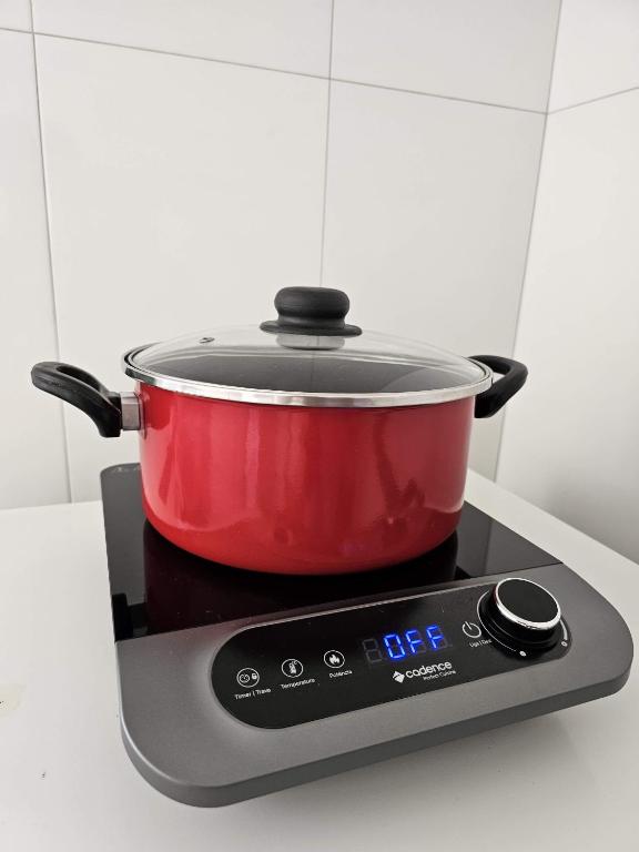 a red pot sitting on top of a stove at AP 3 quartos -2min da ARENA MRV e Expominas- BH in Belo Horizonte