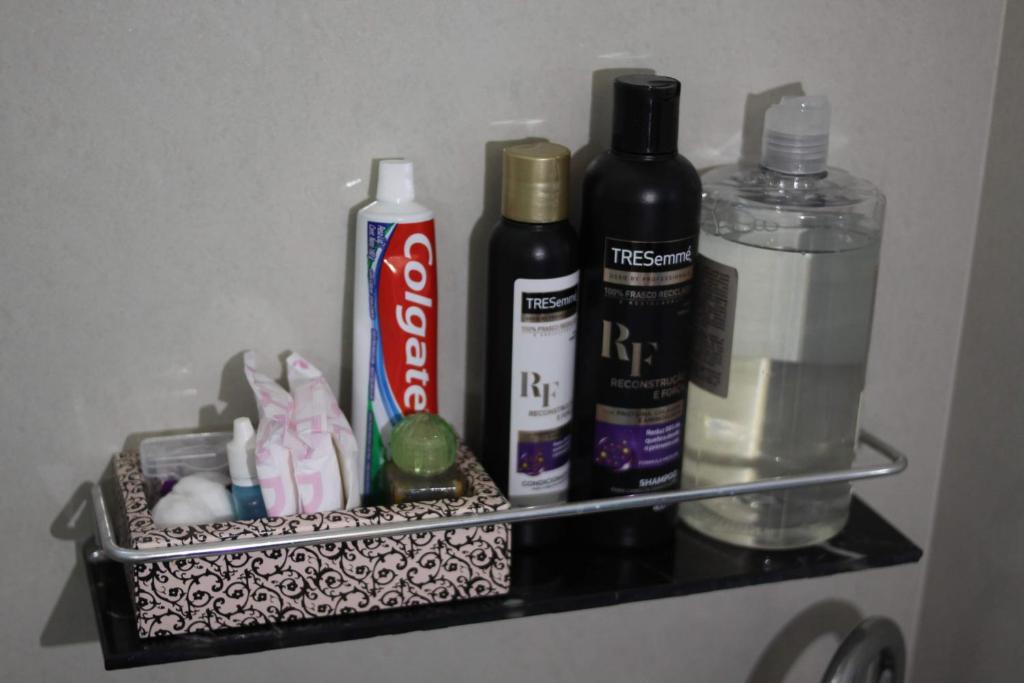 a shelf with toothbrushes and cleaning products on it at AP 3 quartos -2min da ARENA MRV e Expominas- BH in Belo Horizonte