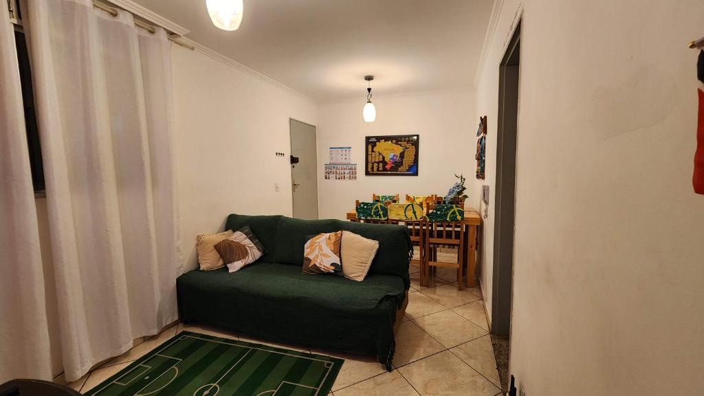 a living room with a green couch and a table at AP 3 quartos -2min da ARENA MRV e Expominas- BH in Belo Horizonte