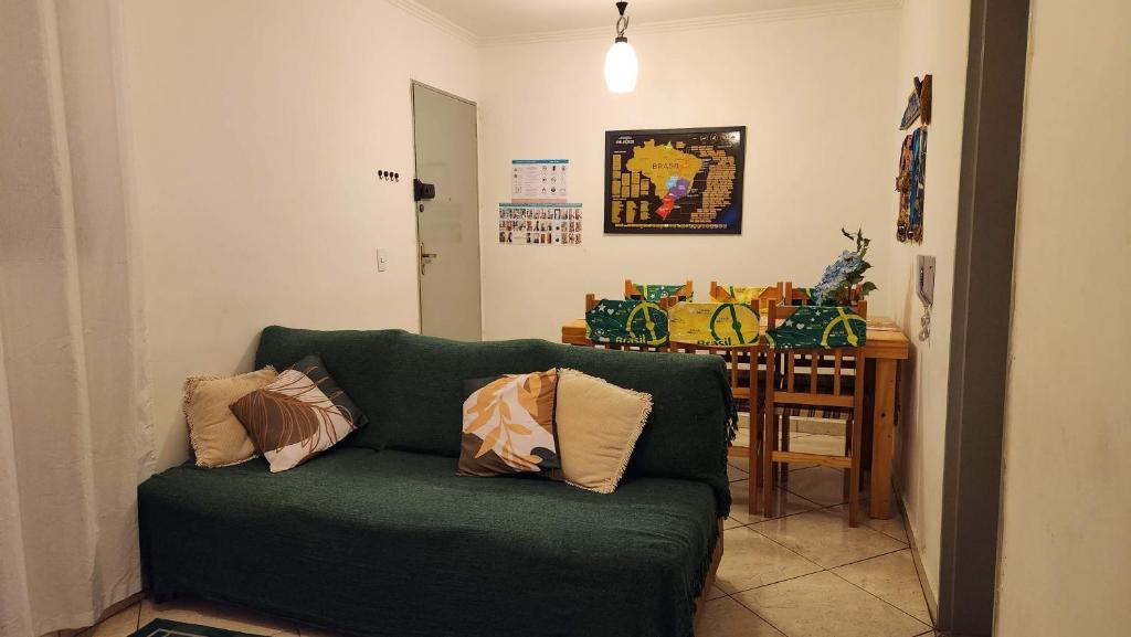 a living room with a green couch and a table at AP 3 quartos -2min da ARENA MRV e Expominas- BH in Belo Horizonte