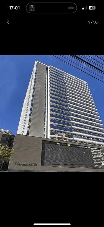 a tall white building with a blue sky in the background at Studio Central Independência 915 in Juiz de Fora
