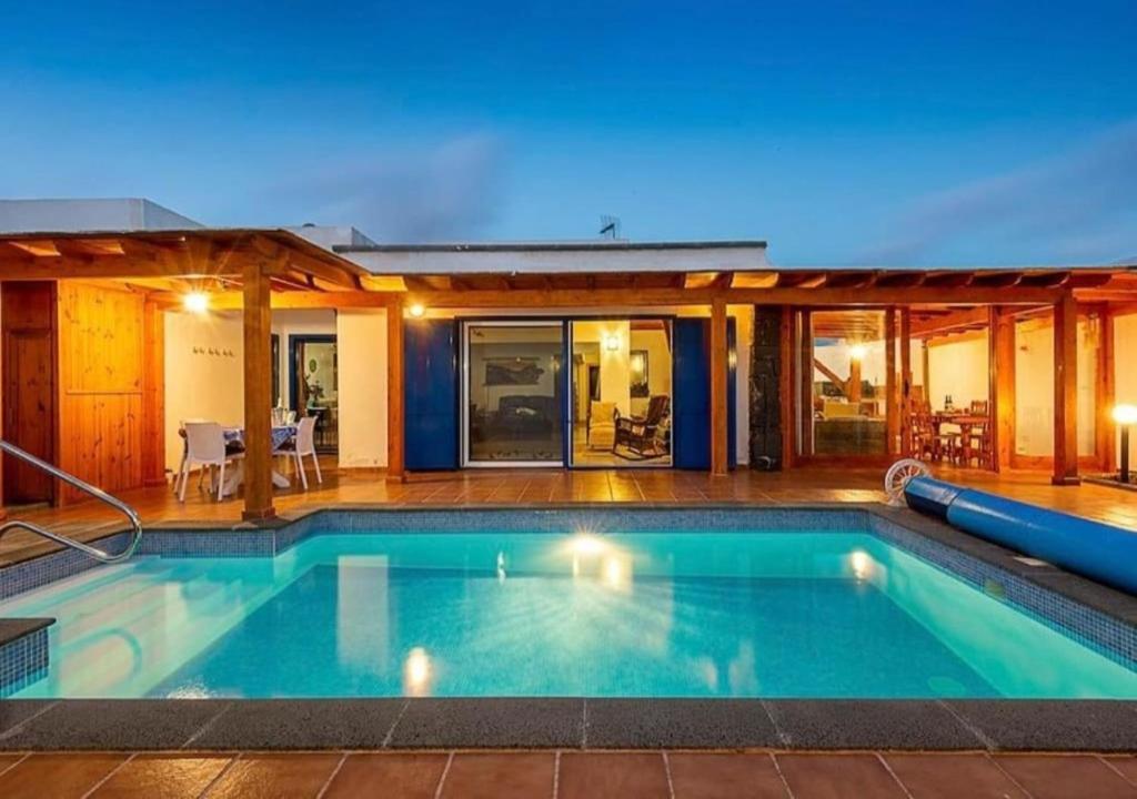 a swimming pool in the backyard of a house at Villa Maiteren Etxea- 4 Beds property with private pool in Playa Blanca