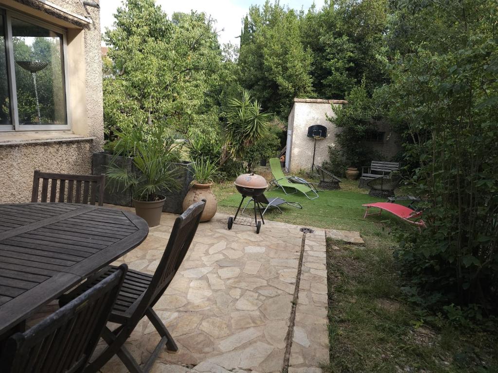 d'une terrasse avec une table et des chaises dans le jardin. dans l'établissement La Villa Toulonnaise-Jardin-Espace, à Toulon