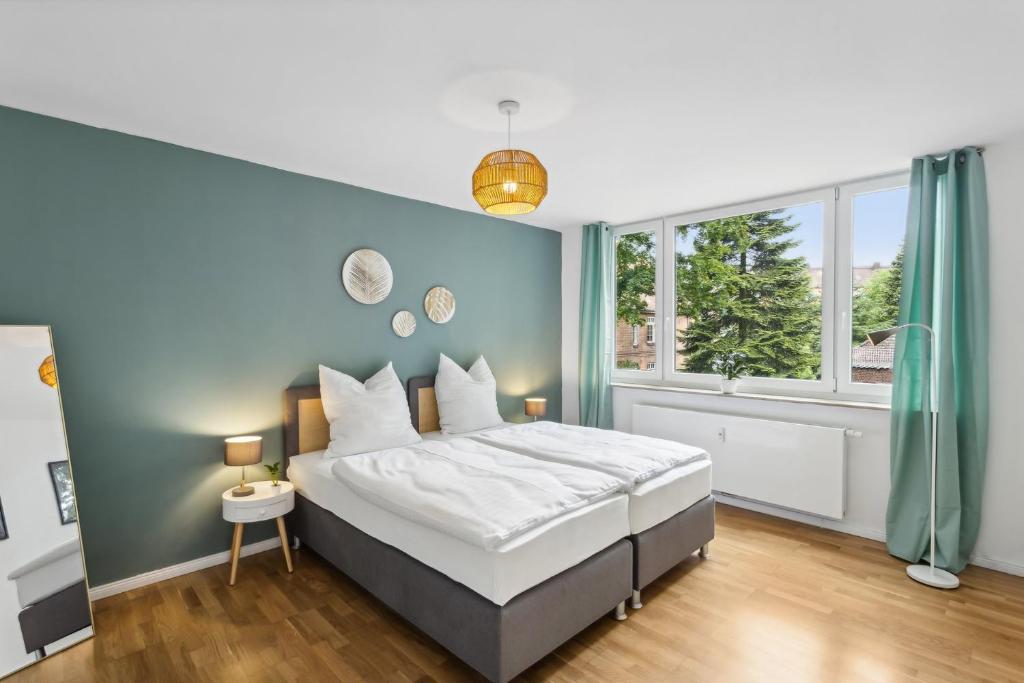 una camera da letto con un letto e una parete blu di Komfort Apartment Küche Balkon 3 Zi a Geesthacht