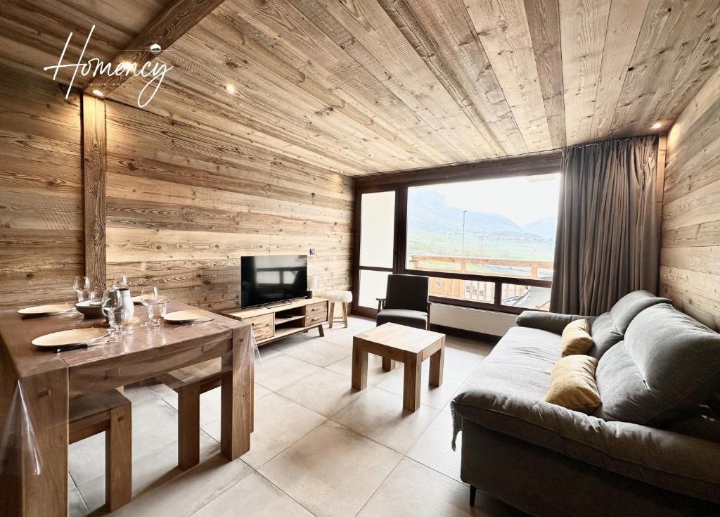 un salon avec un canapé, une table et une télévision dans l'établissement Homency - Résidence le Président 214, à L'Alpe-d'Huez