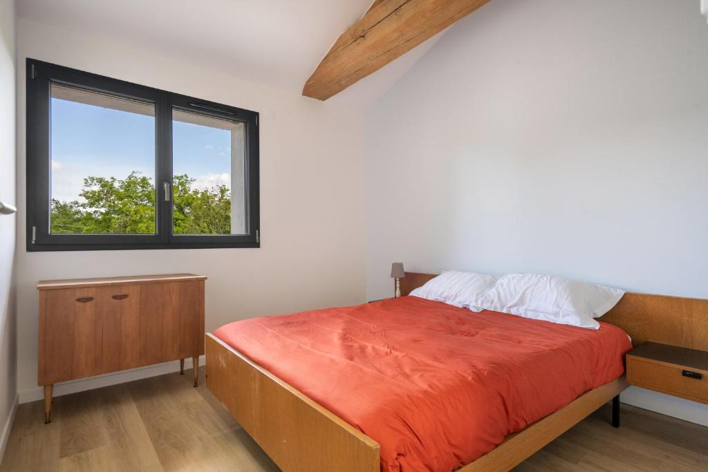 a bedroom with a bed and a window at La maison du Sophora grande maison 3 chambres in Saint-Didier-de-Formans