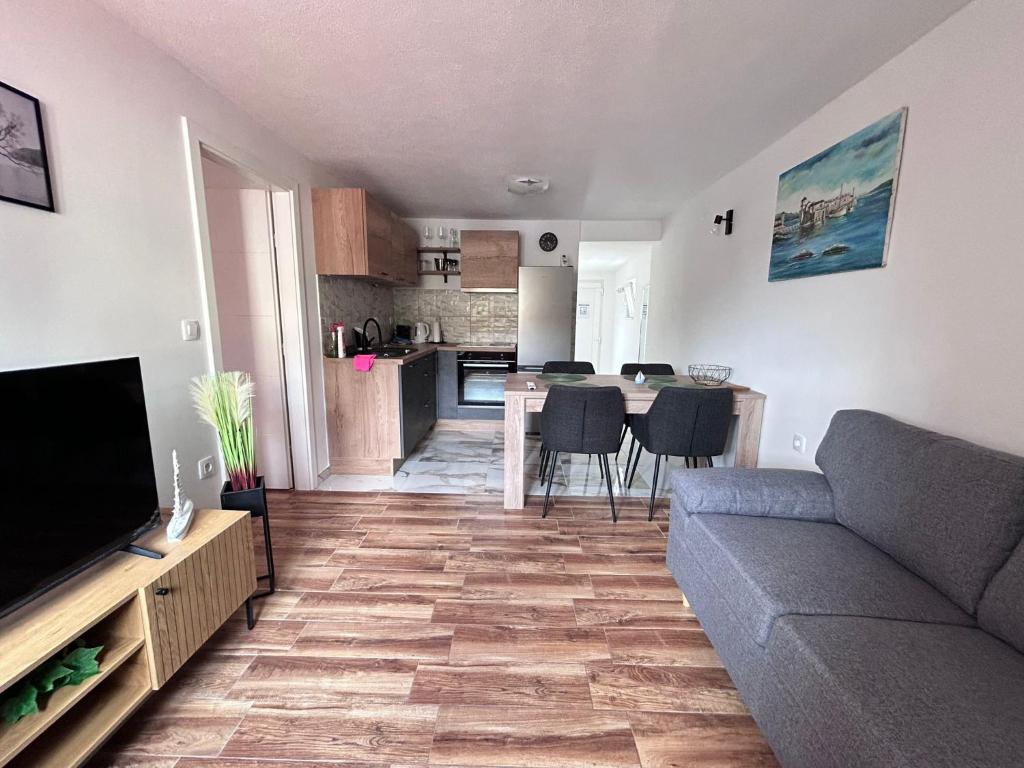 a living room with a couch and a kitchen at Apartment Žega in Kaštela