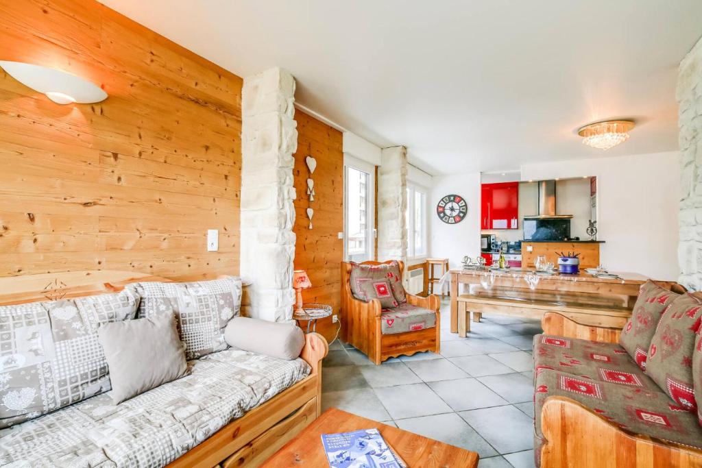 un salon avec un canapé et une cuisine dans l'établissement Résidence Le Bec Rouge - Appartement de charme 3 pièces 8 personnes à Tignes au pied des pistes et proche des commerces dans le quartier du Lac. Vue impr MAE-1681, à Tignes
