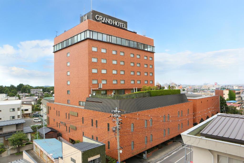 a red brick building with a sign on top of it at Hachinohe Grand Hotel in Hachinohe