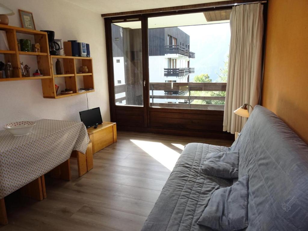 - un salon avec un lit, une table et une fenêtre dans l'établissement Résidence Rey - Plan Peisey - Appartement 2 pièces 6 personnes à Plan Peisey proche des commerces et des pistes MAE-1885, à Peisey-Nancroix