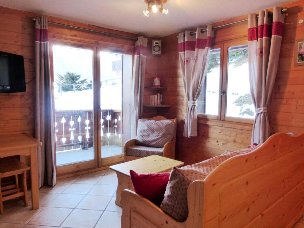 a living room with a couch and a table and windows at Résidence Bergerie Des 3 Vallees D - Joli appartement 3 pièces 4 personnes situé sur Les Allues dans un quartier calme MAE-2122 in Les Allues