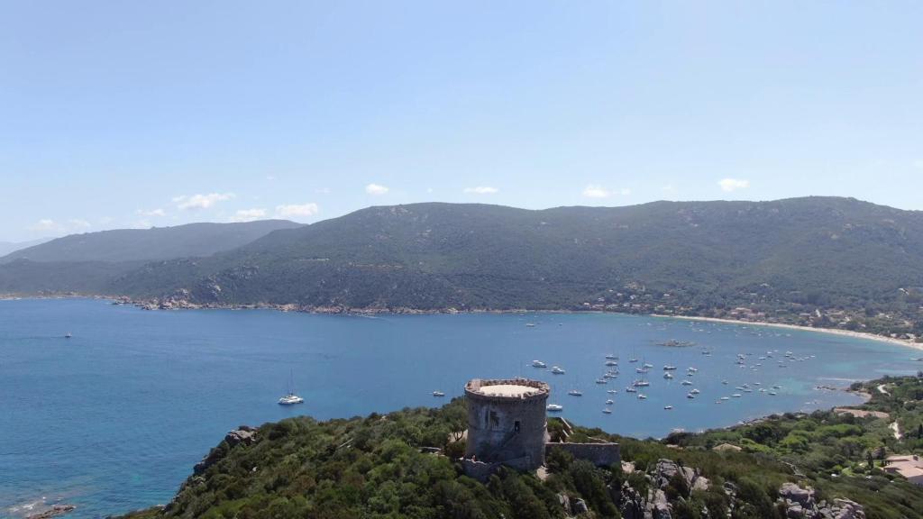 un château situé sur une colline à côté d'une étendue d'eau dans l'établissement T2 Les pieds dans l'eau, à Belvédère