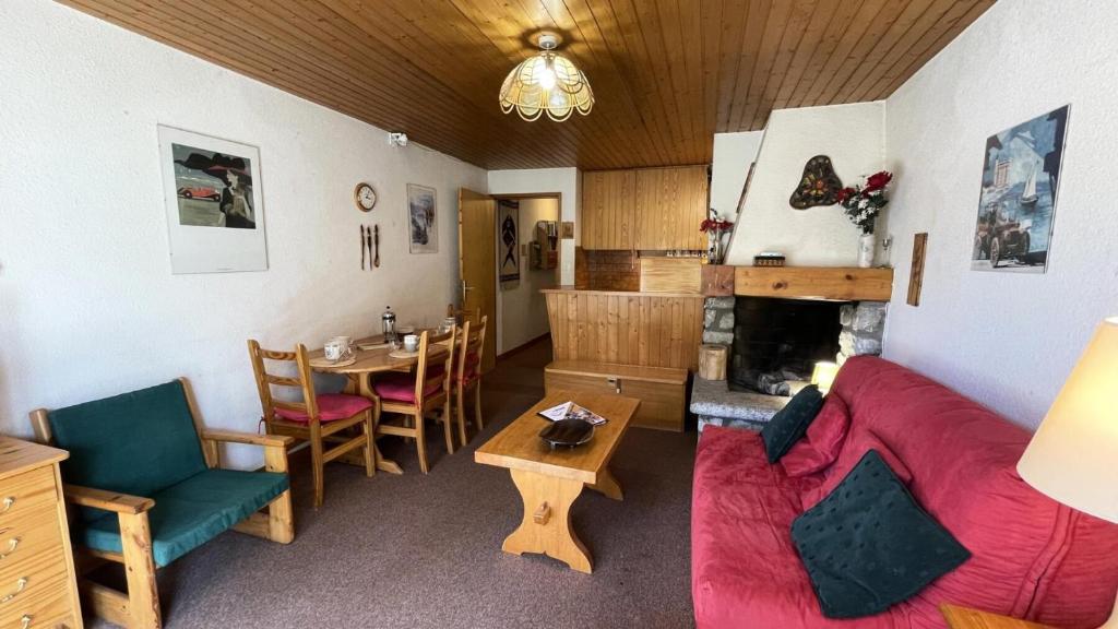 un salon avec un canapé rouge et une table dans l'établissement Résidence Chasseforet - Appartement 2 pièces 4 personnes situé à Méribel sur la route des Chalets proche des pistes MAE-2107, à Les Allues