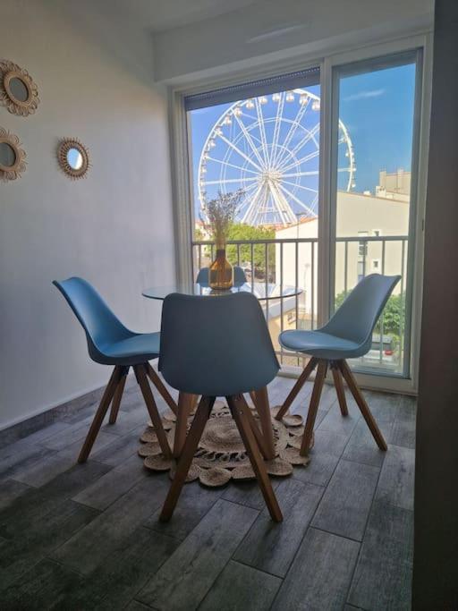une salle à manger avec une table et des chaises et une grande roue dans l'établissement Appartement Centre-Port Cap d Agde, au Cap d'Agde