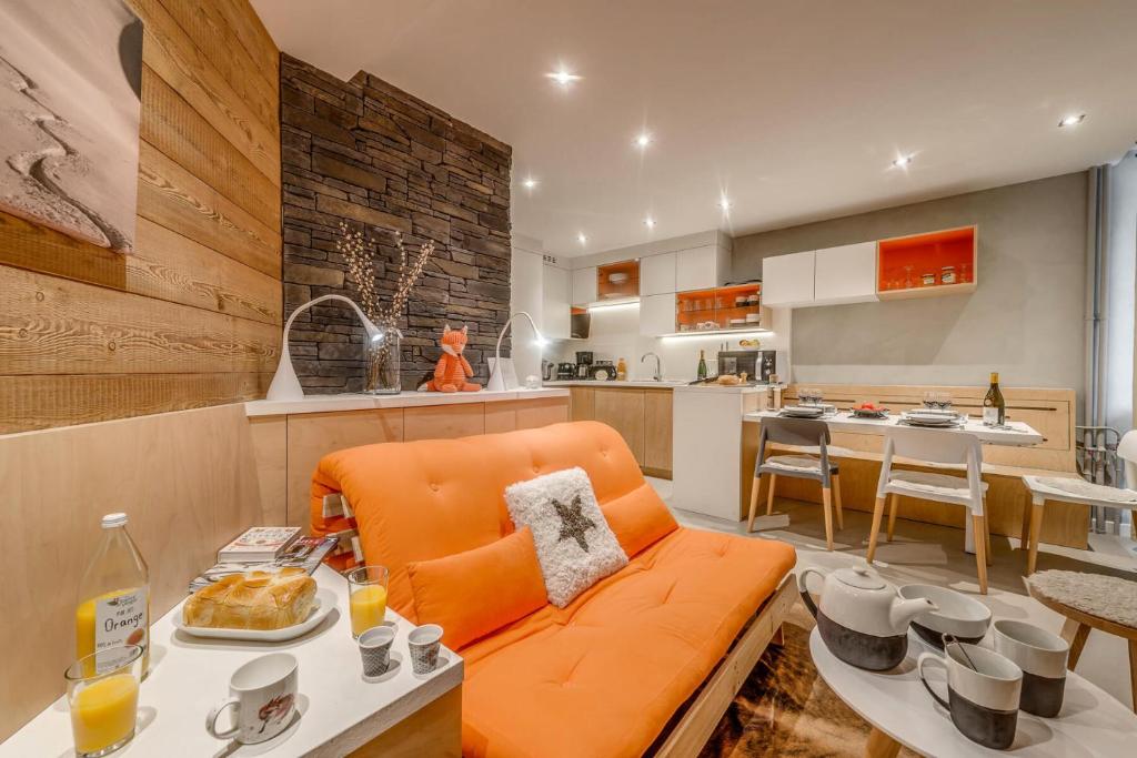un salon avec un canapé orange et une cuisine dans l'établissement Résidence RÉsidence 2100 B - 2 pièces 4 entièrement rénové 3 MAE-3387, à Tignes