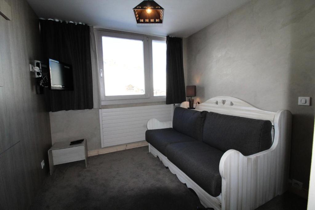 Cette chambre comprend un lit, une fenêtre et une télévision. dans l'établissement Résidence Palafour - Studio 2 - Rénové, confortable - nord vue montagne MAE-3402, à Tignes