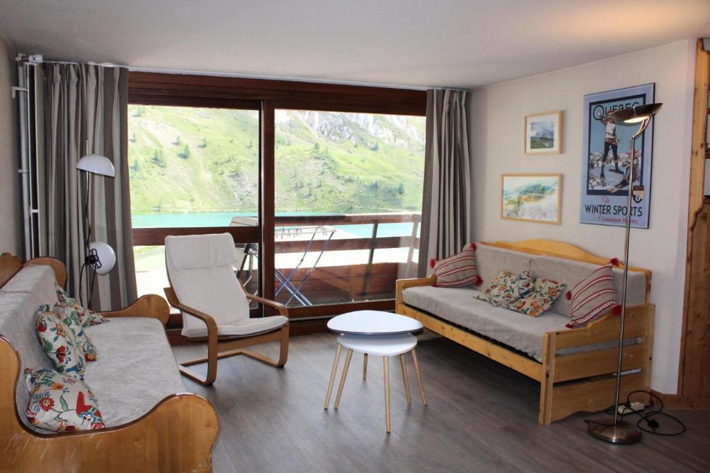 un salon avec un canapé et des chaises et une grande fenêtre dans l'établissement Résidence Palafour - 3 pièces familial, spacieux, 2 salle de bain/douche - balcon vue lac MAE-3443, à Tignes