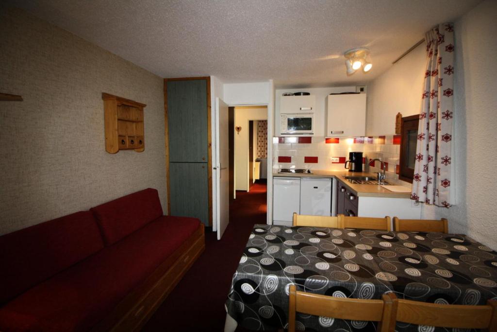un salon avec un canapé rouge et une cuisine dans l'établissement Résidence Home Club 2 - Appartement confortable, soigné MAE-3468, à Tignes