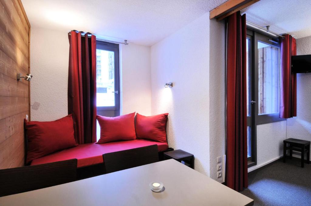 - un salon avec un canapé rouge et une fenêtre dans l'établissement Résidence Les Glaciers 3 - Studio pour 4 Personnes 29, à Mâcot La Plagne