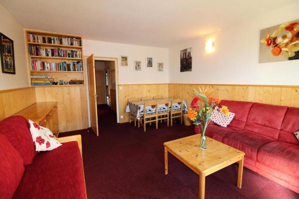 un salon avec un canapé rouge et une table dans l'établissement Résidence Bec Rouge - vue lac, sur les pistes MAE-3545, à Tignes