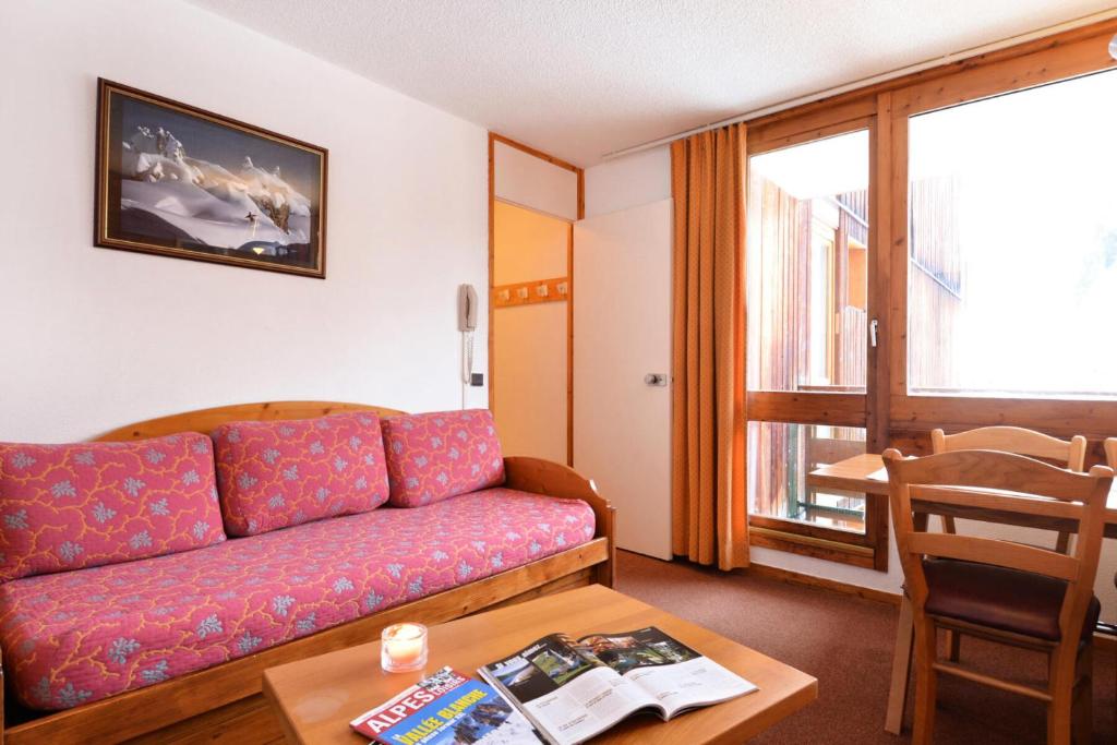un salon avec un canapé et une table dans l'établissement Résidence Carroley B - 2 Pièces pour 5 Personnes 91, à Mâcot La Plagne