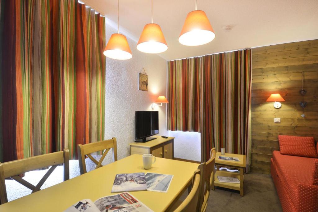 un salon avec une table et une télévision dans l'établissement Résidence Croix Du Sud - Studio pour 4 Personnes 37, à Mâcot La Plagne