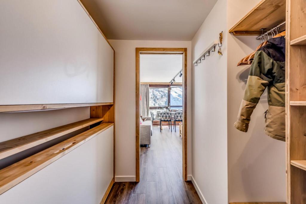 un couloir avec une porte menant à une salle à manger munie d'un uniforme militaire dans l'établissement Résidence Palafour - Studio 4 rénové, soigné, confortable - balcon vue lac MAE-3675, à Tignes