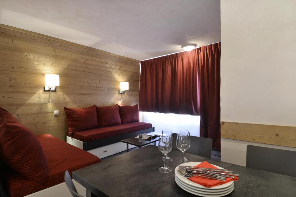 - un salon avec un canapé et une table avec des verres à vin dans l'établissement Résidence Saint Jacques A - 2 Pièces pour 5 Personnes 12, à Mâcot La Plagne