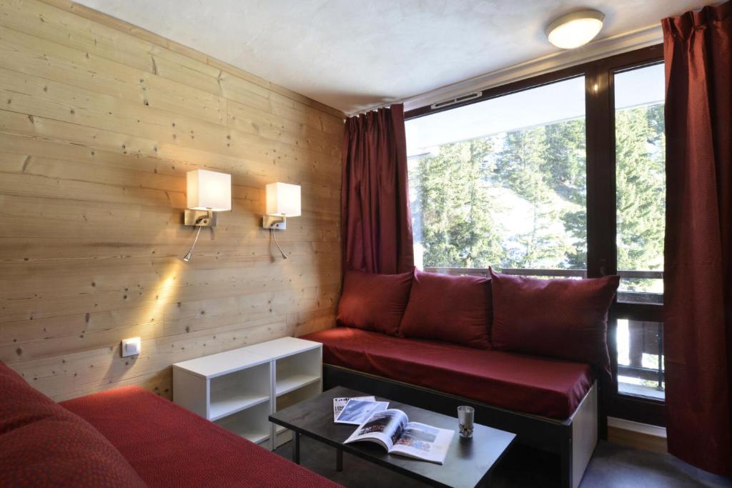 - un salon avec un canapé rouge et une fenêtre dans l'établissement Résidence Saint Jacques A - Studio pour 4 Personnes 46, à Mâcot La Plagne