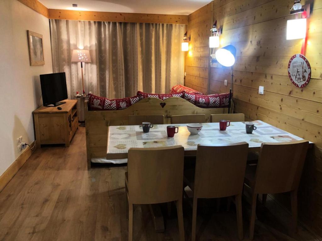 une salle à manger avec une table, des chaises et un canapé dans l'établissement Résidence Nereides - 3 Pièces pour 7 Personnes 67, à Mâcot La Plagne