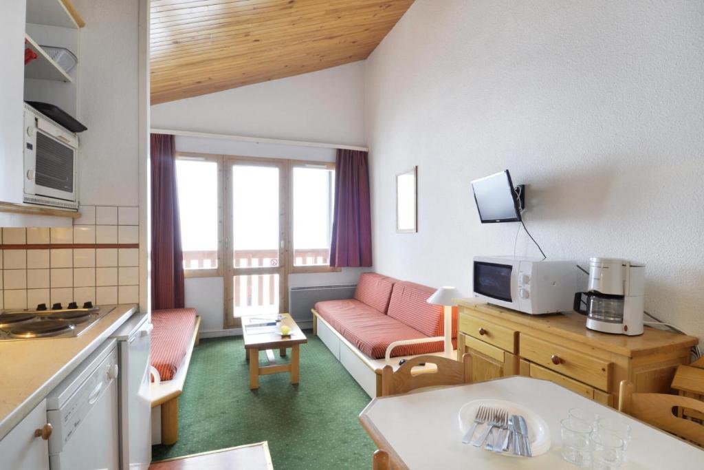 un petit salon avec un canapé et une cuisine dans l'établissement Résidence Themis - 2 Pièces pour 6 Personnes 63, à Mâcot La Plagne
